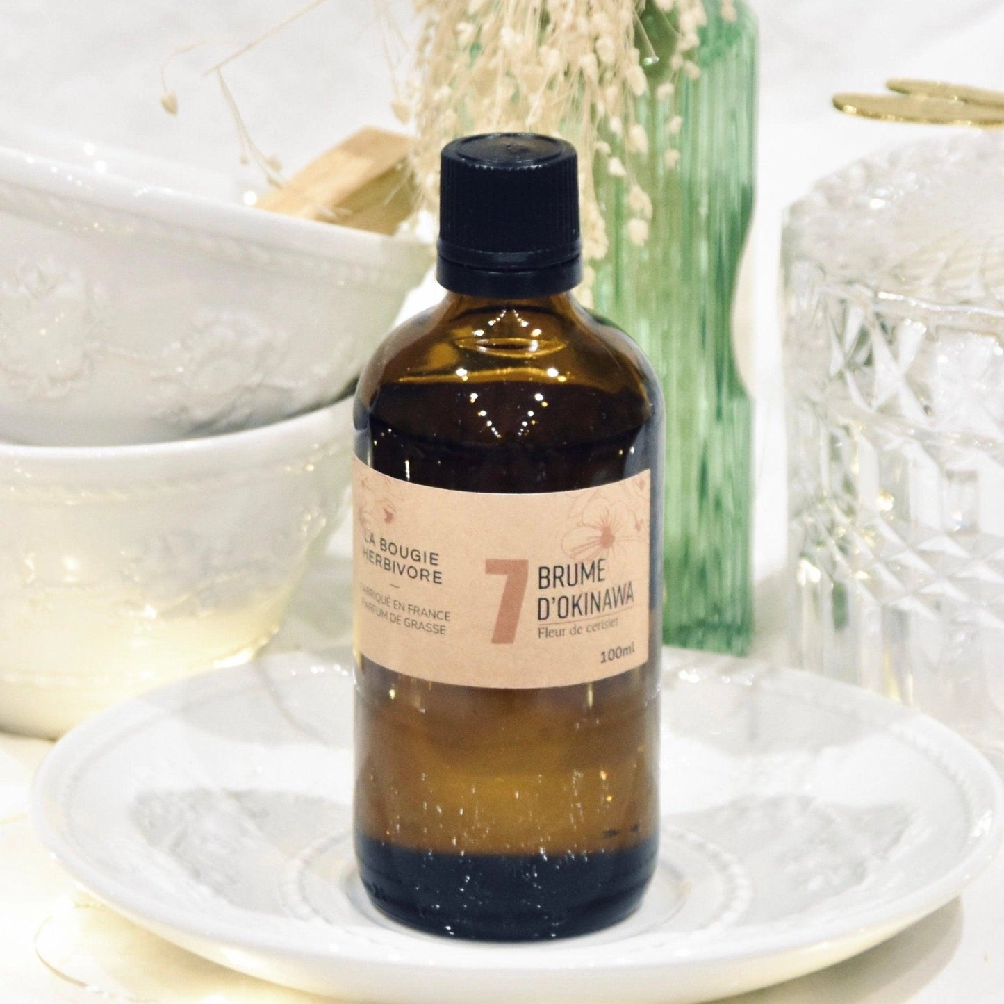 Diffuseur parfum fleur de cerisier de La Bougie Herbivore en bouteille marron sur une belle table décorée
