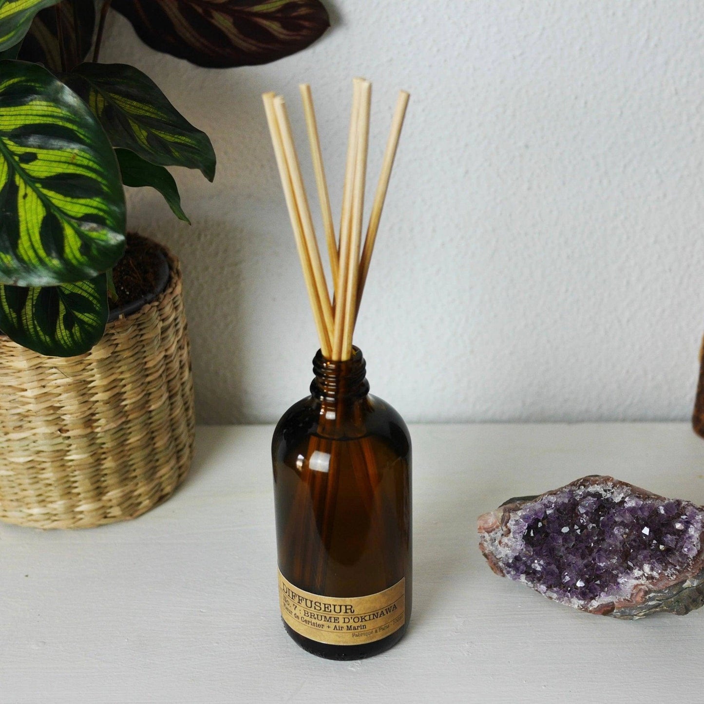 Diffuseur parfum fleur de cerisier de La Bougie Herbivore avec tiges en bambou dans un cadre naturel