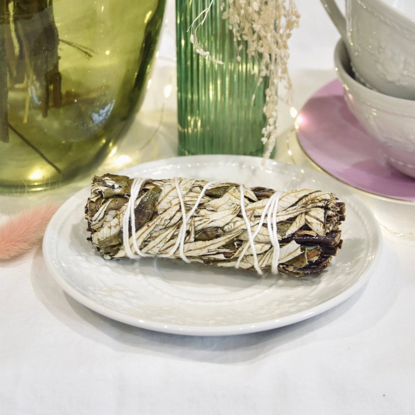 Fagot sauge noire de La Bougie Herbivore sur une assiette avec décoration apaisante
