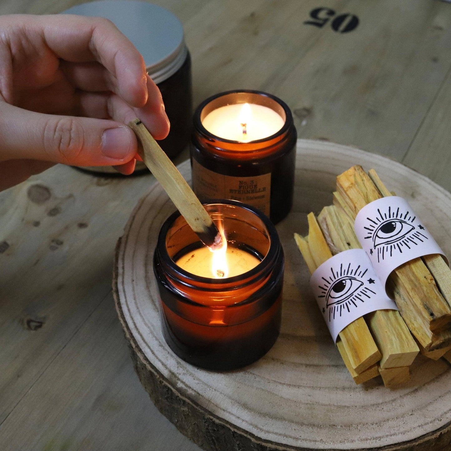 Allumage de bougie cire de soja sans parfum dans un pot en verre jaune sur une table en bois