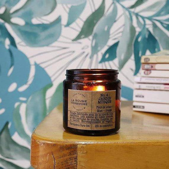 Bougie fleur de lotus et musc de La Bougie Herbivore dans un pot sur une table en bois
