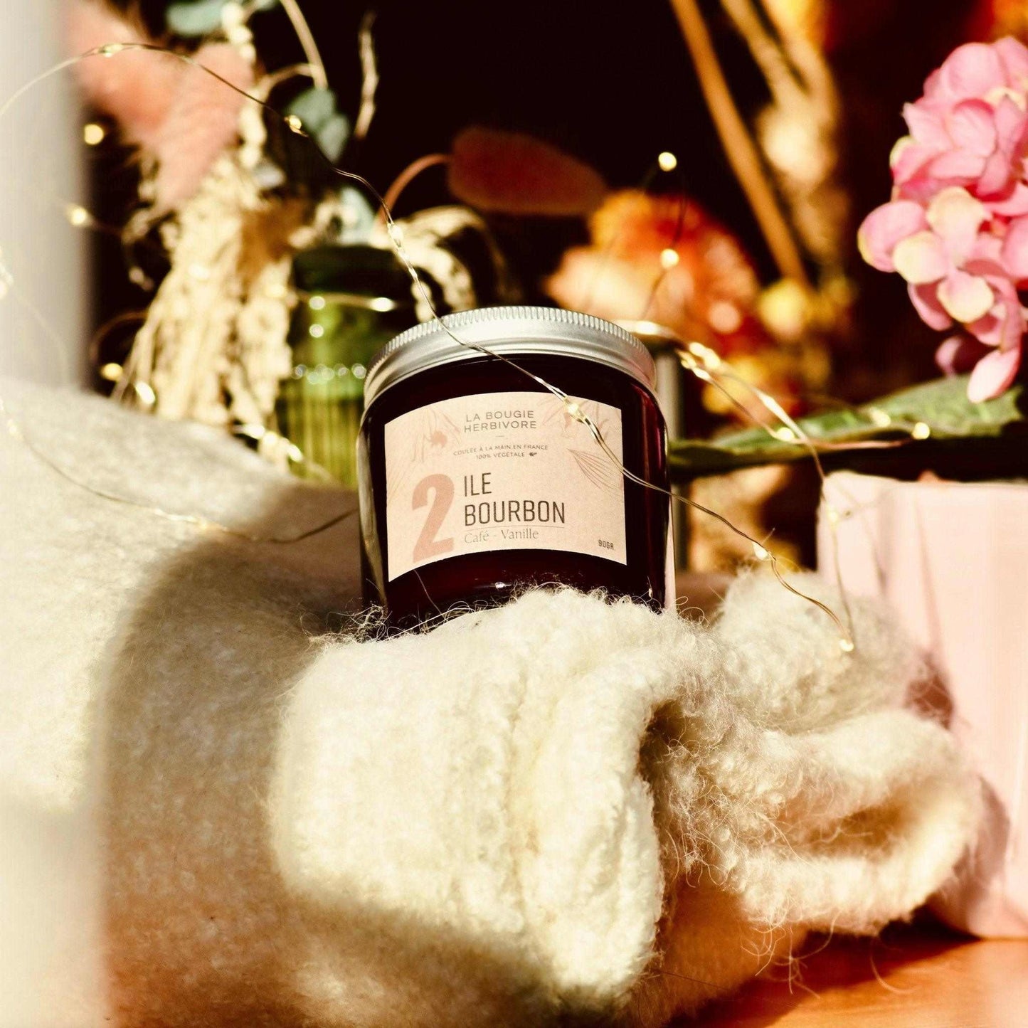 Bougie parfumée café vanille de La Bougie Herbivore dans un décor élégant avec des fleurs