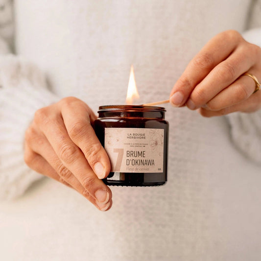 Bougie parfumée fleur de cerisier allumée avec étiquette Brume d'Okinawa de La Bougie Herbivore, 90g