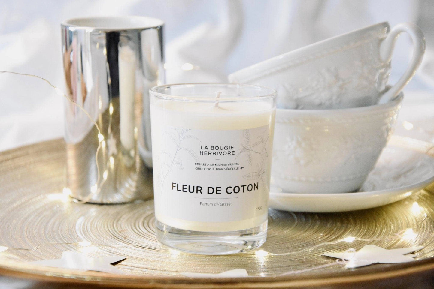 Bougie parfumée fleur de coton 150g de La Bougie Herbivore sur un plateau décoratif avec des tasses en porcelaine