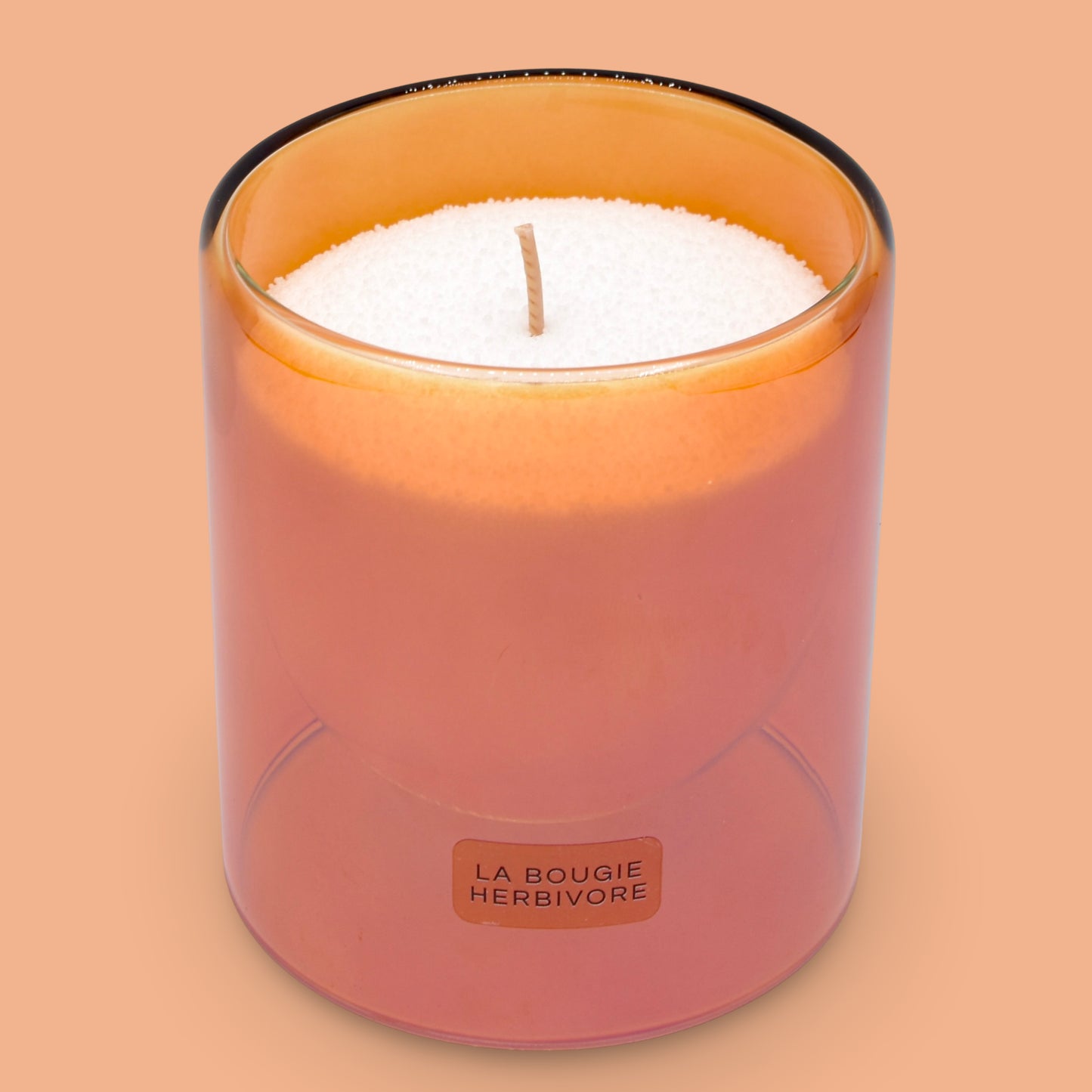 Bougie perlée parfumée made in France dans un récipient en verre orange avec une mèche en bois