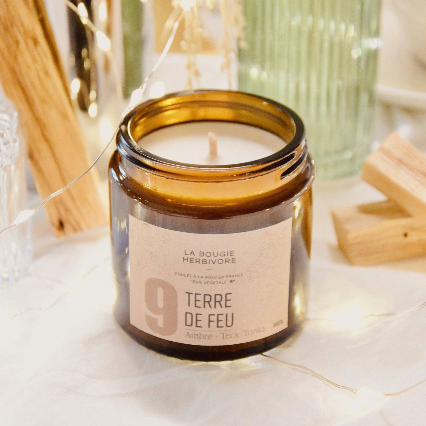 Bougie parfumée ambre teck dans un joli pot en verre de La Bougie Herbivore, avec une étiquette élégante
