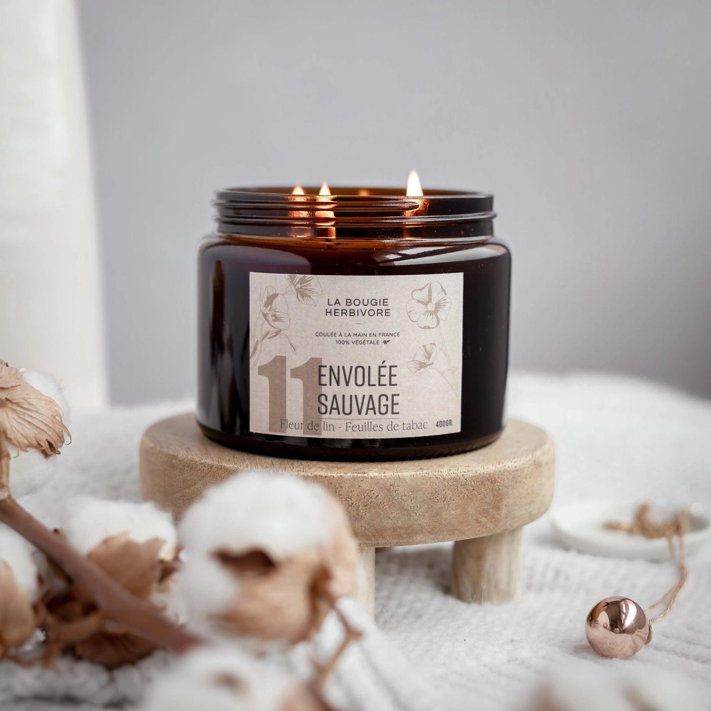 Bougie Envolée Sauvage de La Bougie Herbivore avec trois mèches dans un pot en verre marron