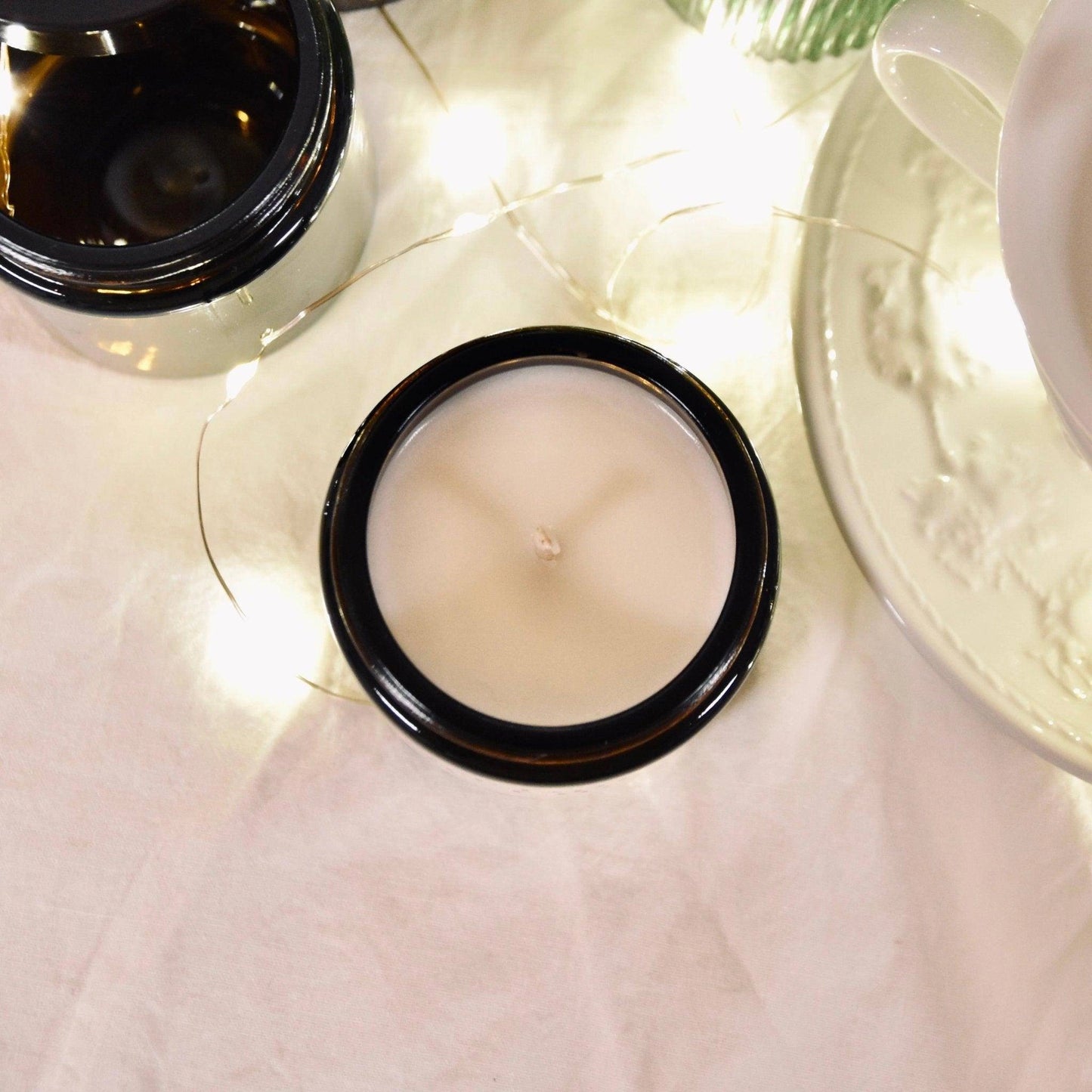 Bougie parfumée orientale de La Bougie Herbivore dans un pot noir avec une mèche visible