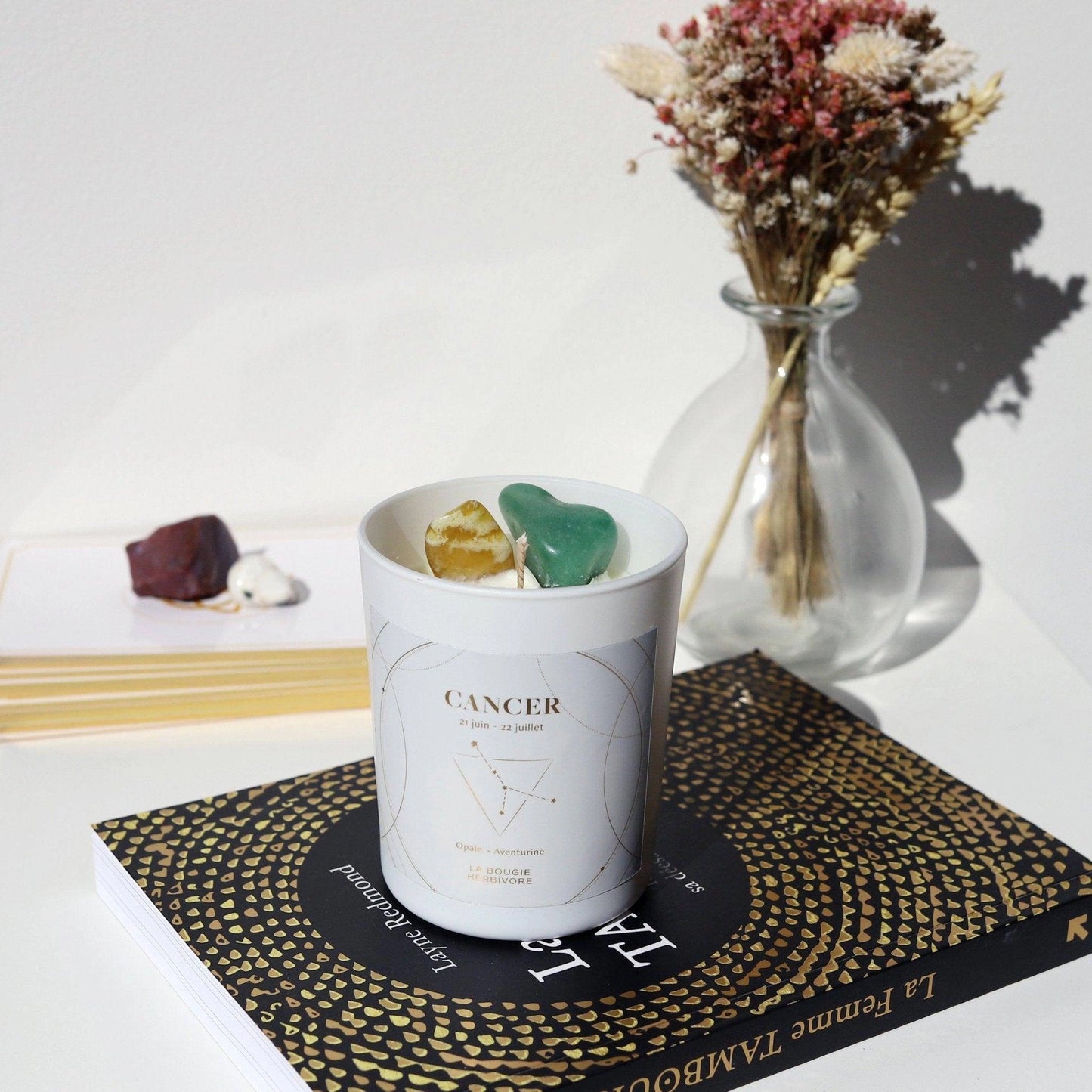Bougie signe astrologique Cancer avec pierres naturelles et design élégant sur un livre