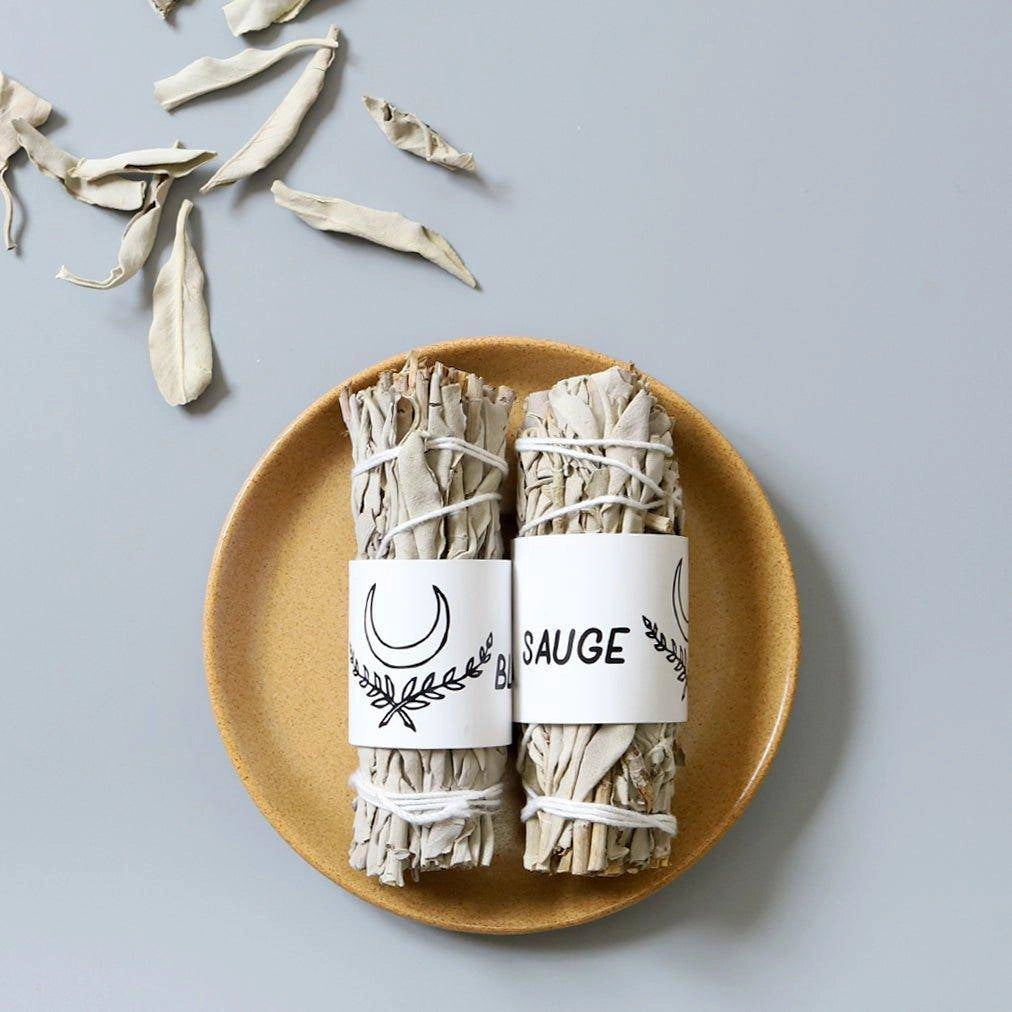 Bâtonnets d'encens sauge blanche écologique de La Bougie Herbivore présentés sur une assiette élégante