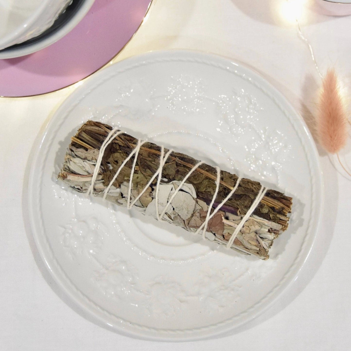 Bâtonnet d'encens La Bougie Herbivore sauge blanche et menthe purification sur une assiette décorative