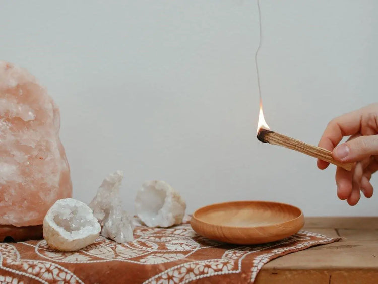 Bâton de fumigation en cours d'utilisation avec un support en bois et des cristaux pour purifier l'espace
