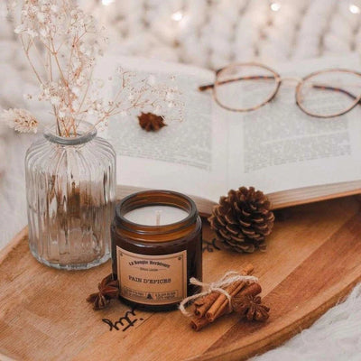 Bougie artisanale de Noël Pâté d'épices de La Bougie Herbivore sur un plateau en bois avec décoration ambiance hivernale